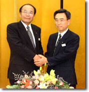 統合調印式で握手する佐藤会長(左)、上野理事長(右)=東京・有楽町の農林中金