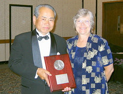 授賞式での須田専務(左)とAAS事務局長のノナ・コイブラさん(右)(7月29日、米国イリノイ州シカゴにて)