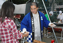 焼きたての牛肉を配る鈴木組合長