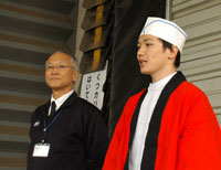 集まったお客に感謝を述べる山中校長（左）と学生長の谷さん。