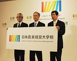 学校名のロゴとシンボルマークを紹介する左から岸康彦校長、浦野光人理事長、金子美登副理事長