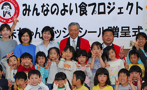 2010年4月5日、笑味ちゃんバッジを市内の幼稚園・保育園に贈呈した。最後列中央が萬代組合長。